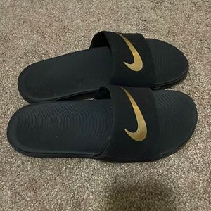 Black Nike slides with Gold Swish